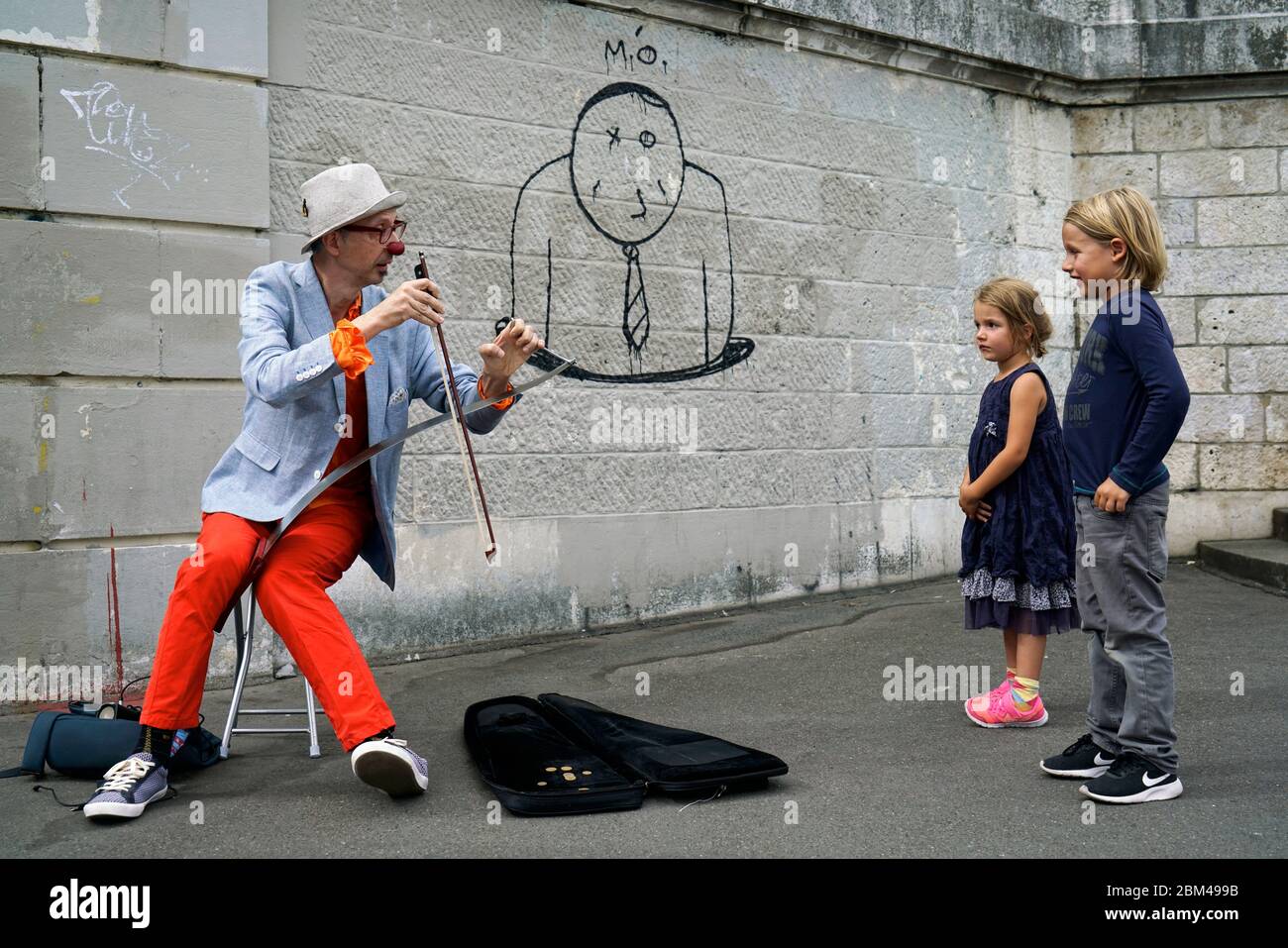 A street performer clown playing music for children in Montmartre.Paris.France Stock Photo