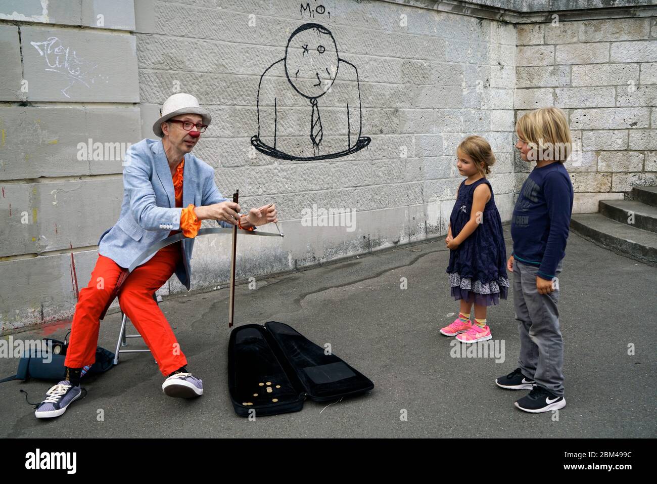 A street performer clown playing music for children in Montmartre.Paris.France Stock Photo