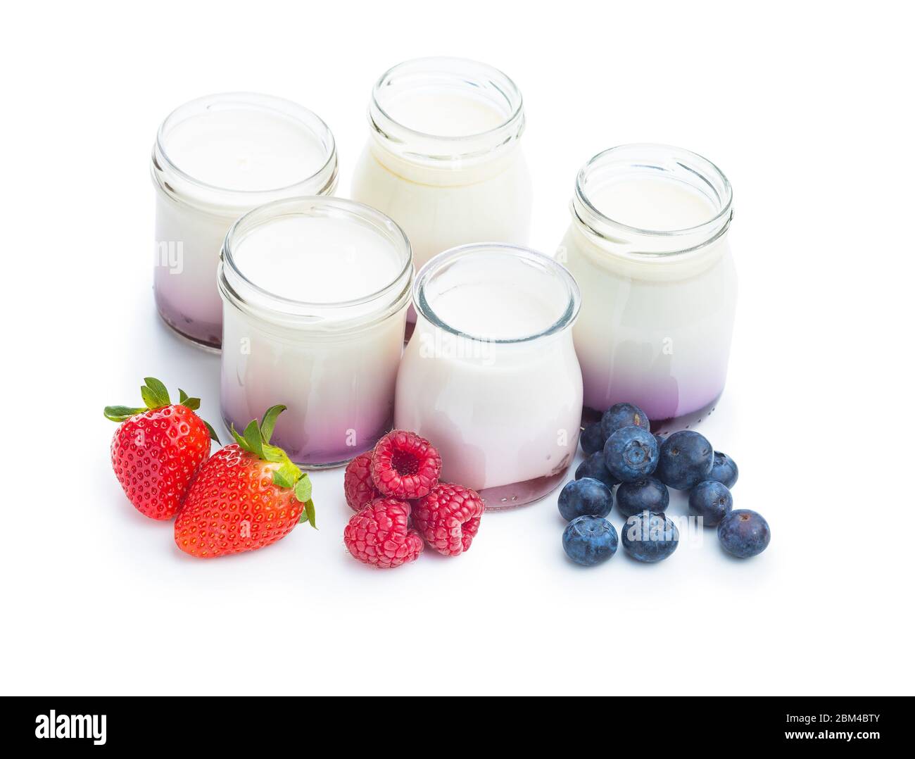 White fruity yogurt in jar and strawberries, blueberries, raspberries isolated on white background. Stock Photo