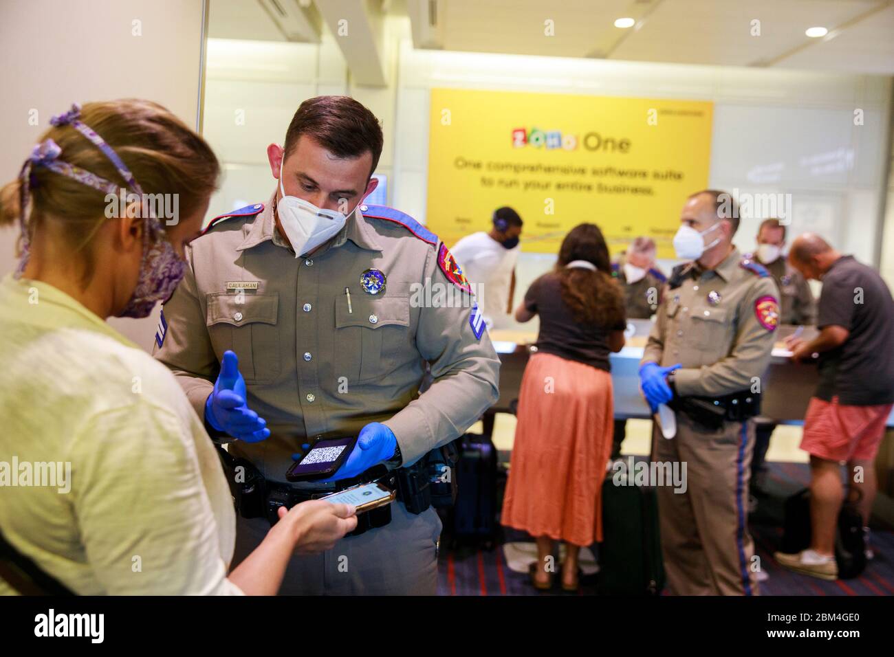 Dallas, United States. 06th May, 2020. Police officers wear face masks as a preventive measure while verifying the identification of passengers arriving at an American Airlines flight in Texas during quarantine amid Coronavirus.Passengers were asked if they were staying in Texas and those who said they were staying in Texas were told to self-quarantine for 14 days under an order from Texas Governor Greg Abbott. Travels not complying with the order are subject to a 1000-dollar fine and either 180 days in jail, or both. Credit: SOPA Images Limited/Alamy Live News Stock Photo