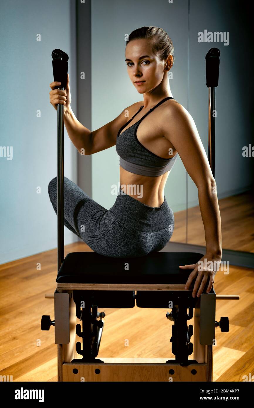 Pilates reformer chair woman fitness yoga gym exercise. Correction of  musculoskeletal system, beautiful body. Correct posture Stock Photo - Alamy