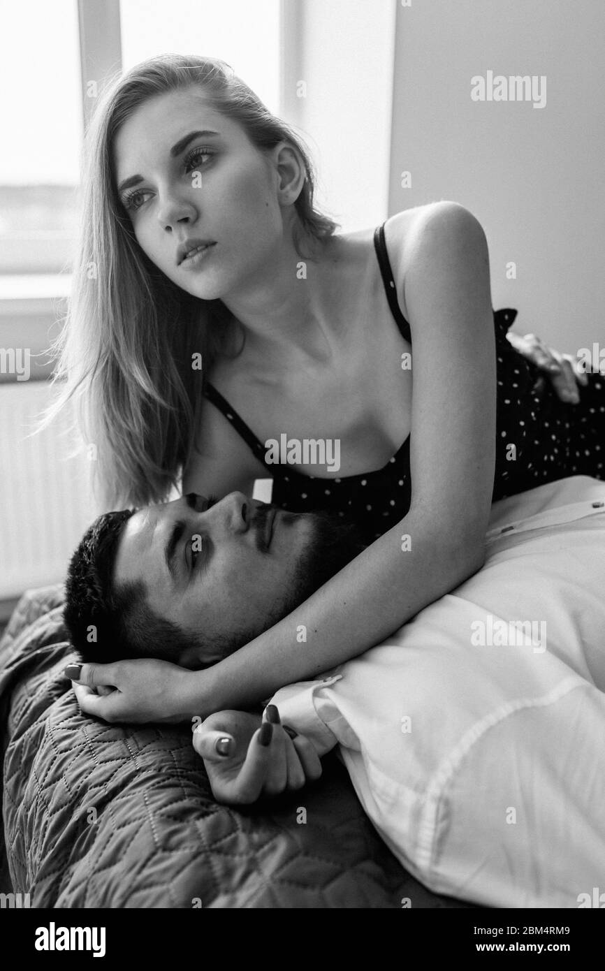 Man lying on the bed while her woman emracing him. Stay home Stock Photo