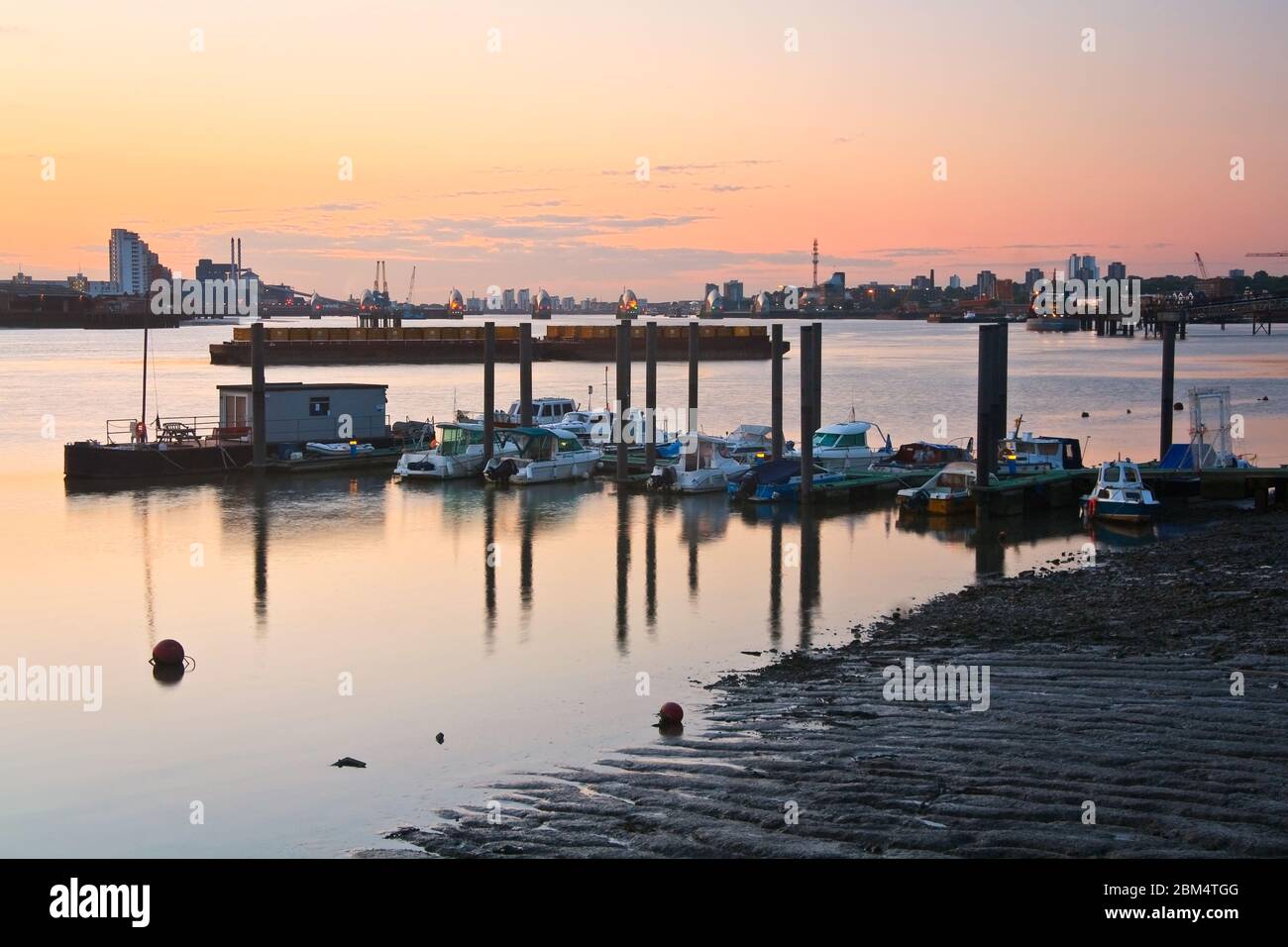 Boats on river Thames and flood barrier in the distance. Stock Photo