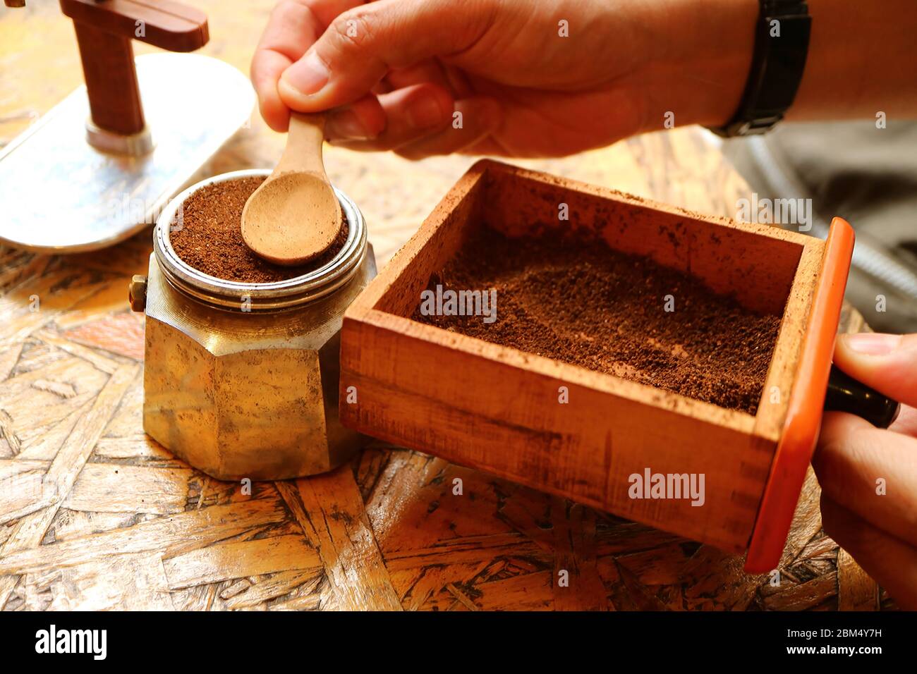 Man's hand preparing ground coffee for brewing aromatic espresso coffee