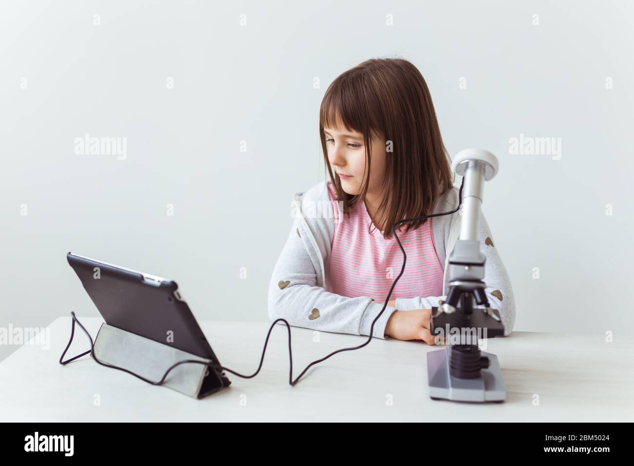 Child girl in science class using digital microscope. Technologies ...