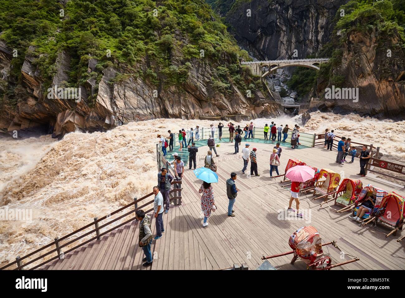 Jizha, China - September 24, 2017: People at the Tiger Leaping Gorge rough waters viewpoint. Stock Photo