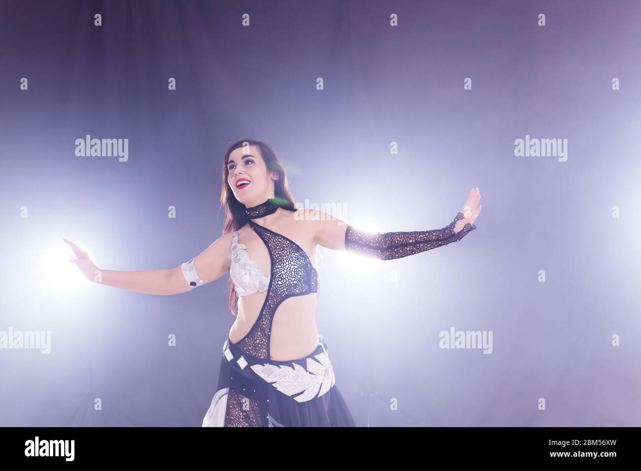 Young woman dancing in Tribal Fusion style. Belly dance on the stage. Stock Photo
