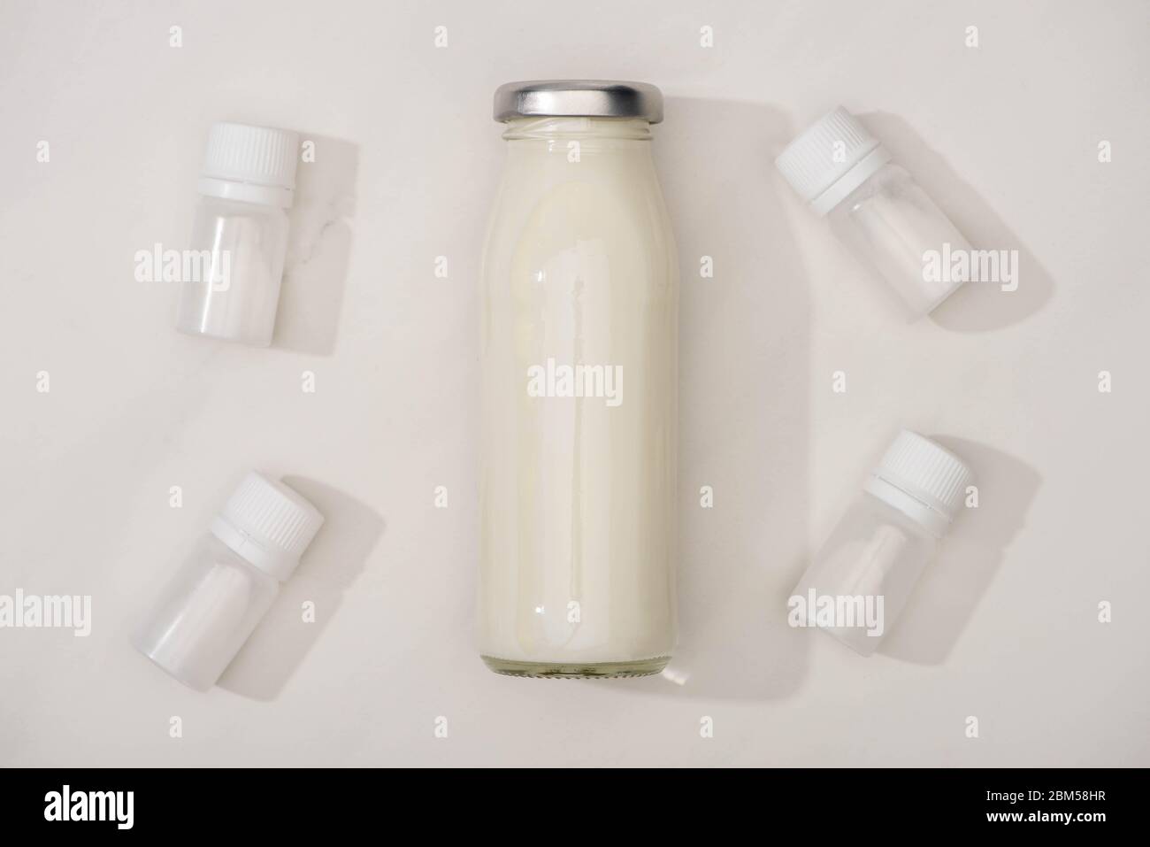 Top view of bottle of homemade yogurt and containers with starter