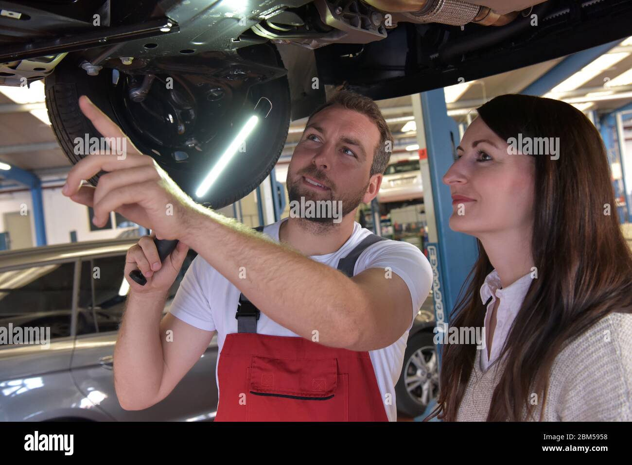 mechanic and customer talking in a workshop to repair a vehicle Stock Photo