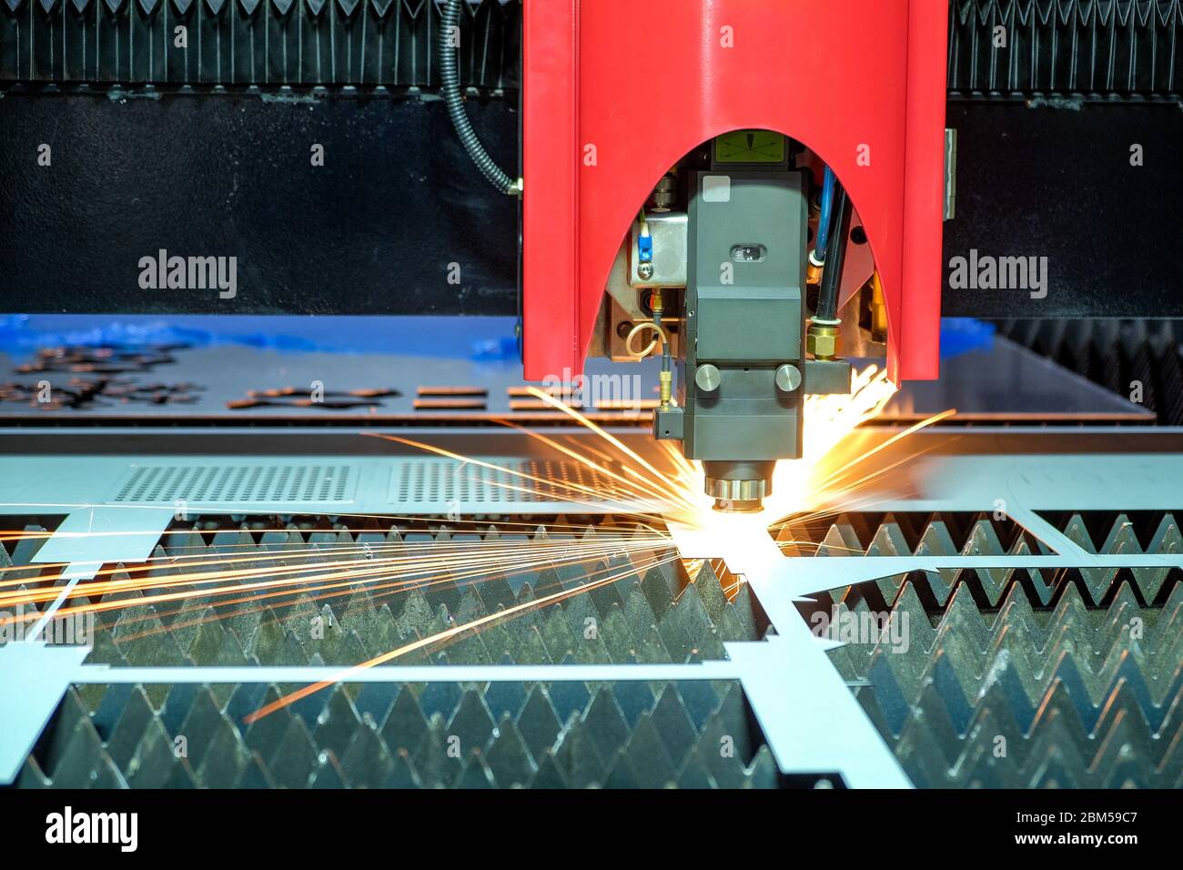 Close-up a laser cutting machine is working with a steel plate until it sparks on smart factory, industry 4.0 Stock Photo