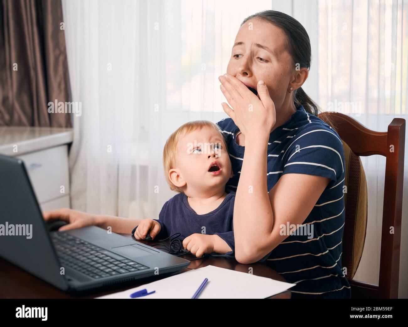 Working from home. Working mother isolated at home with her baby ...