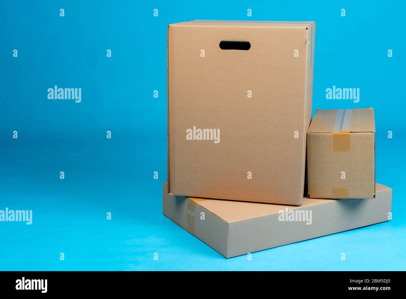 Stack of cardboard boxes on blue background Stock Photo - Alamy