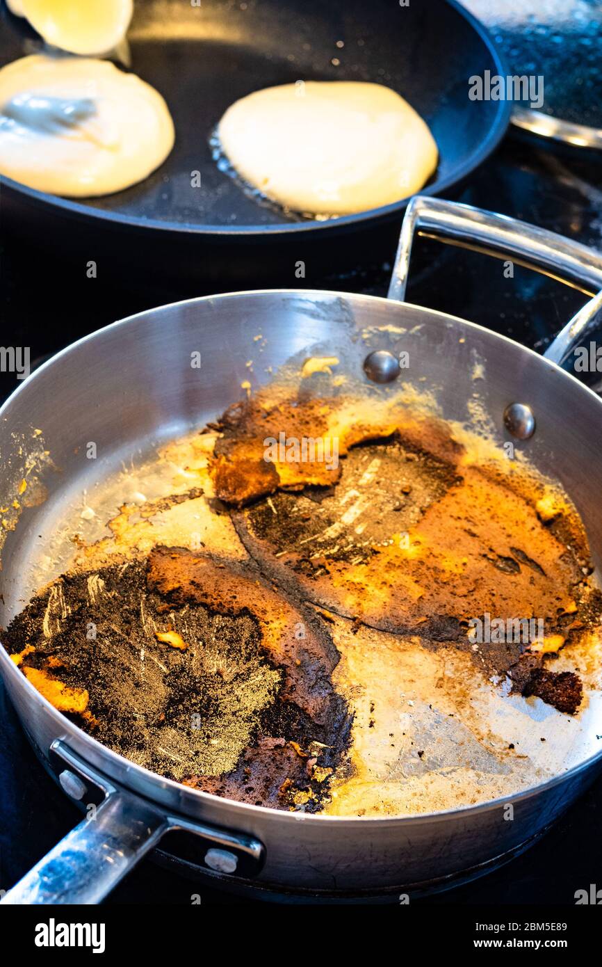 https://c8.alamy.com/comp/2BM5E89/steel-stewpan-with-remains-of-burned-while-cooking-pancakes-on-electric-stove-in-home-kitchen-2BM5E89.jpg