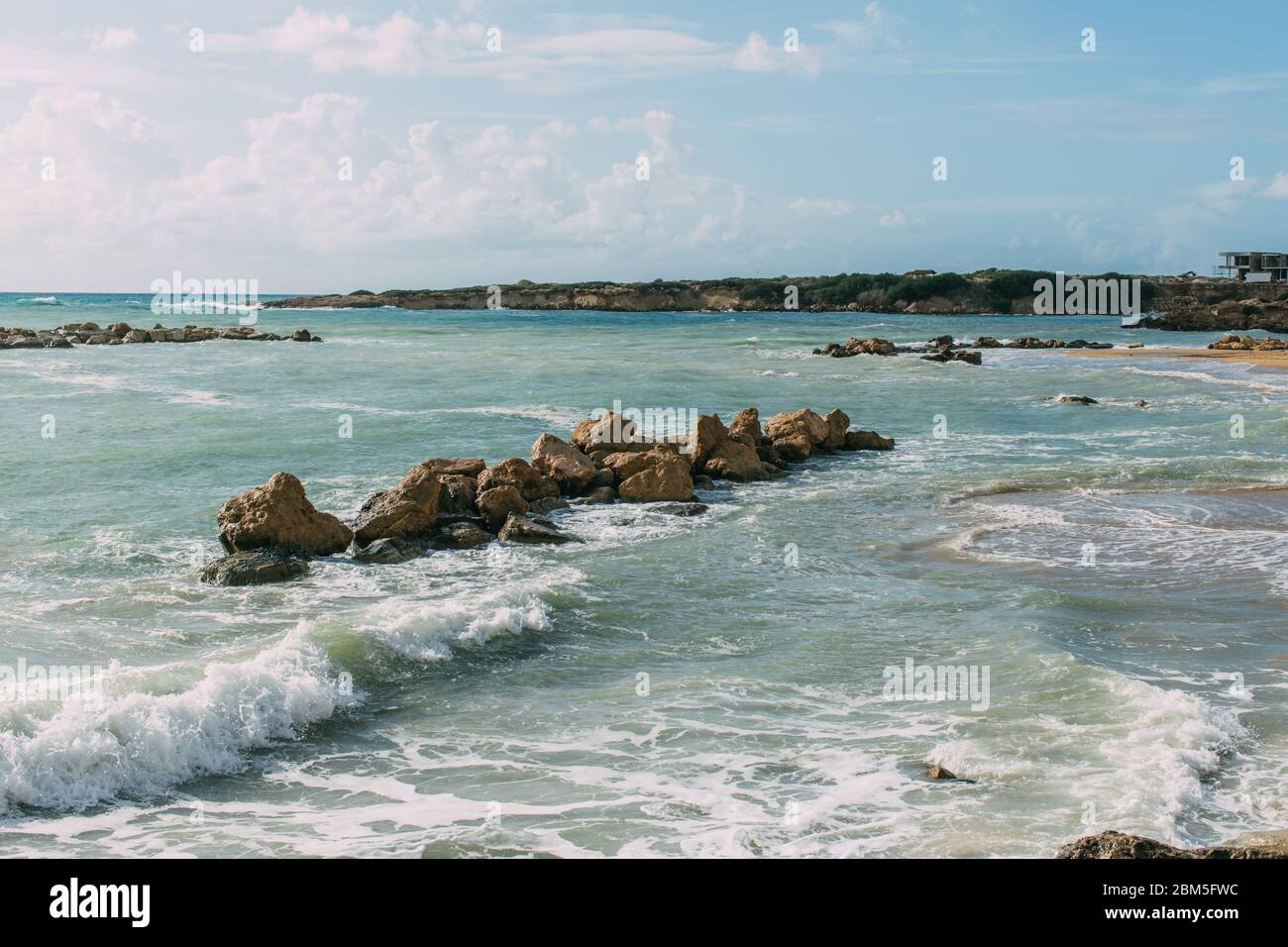 wet rocks in mediterranean sea against blue sky Stock Photo