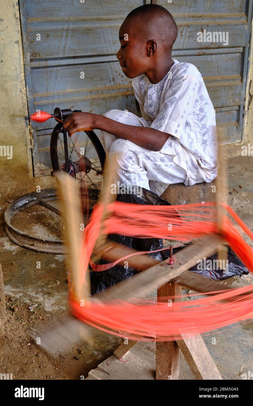 Young boy spinning thread with a handmade spinning wheel Stock Photo ...