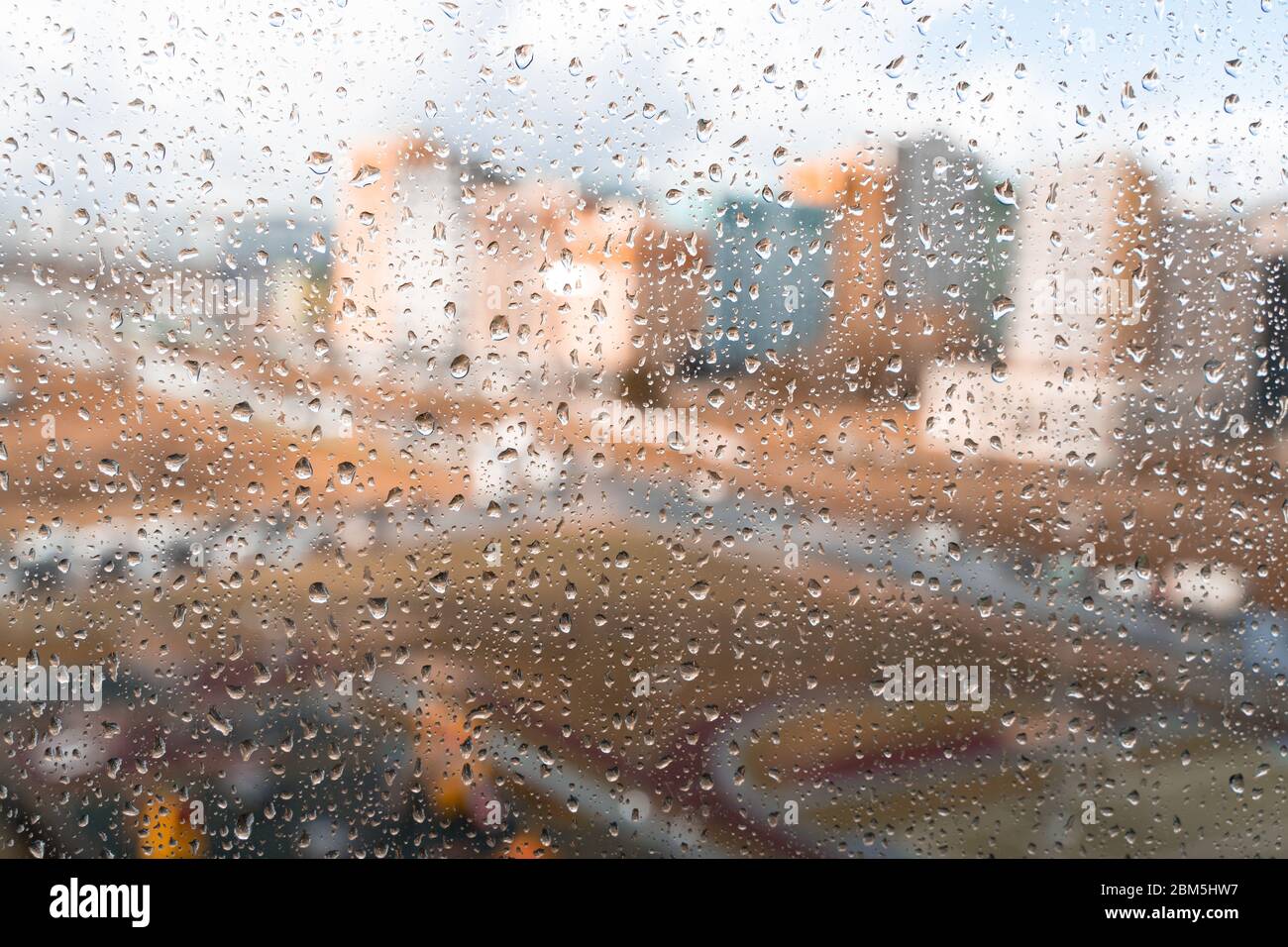 Waterdrops on a glass surface windows with cityscape background Stock Photo