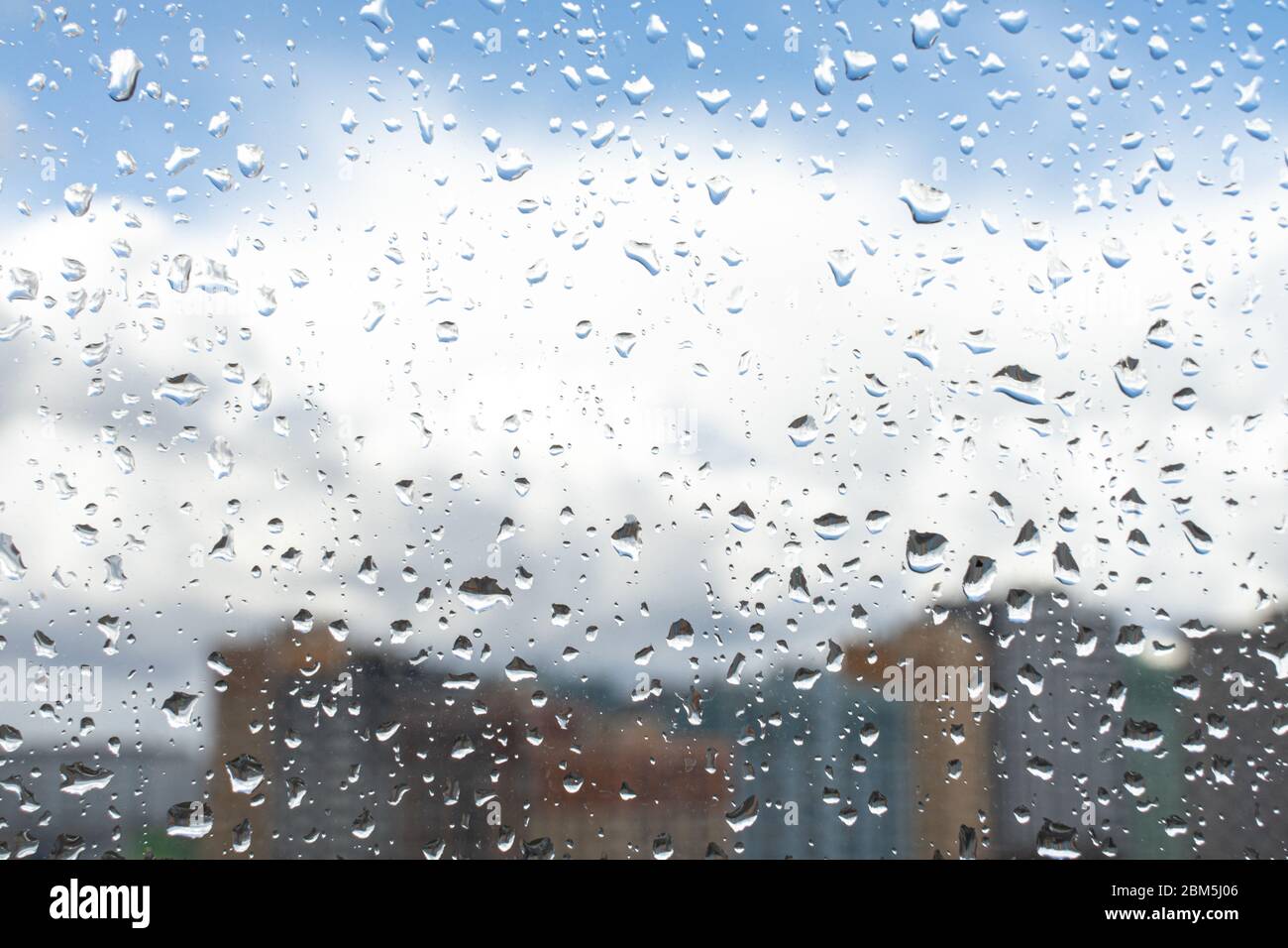 Waterdrops on a glass surface windows with cityscape background Stock Photo