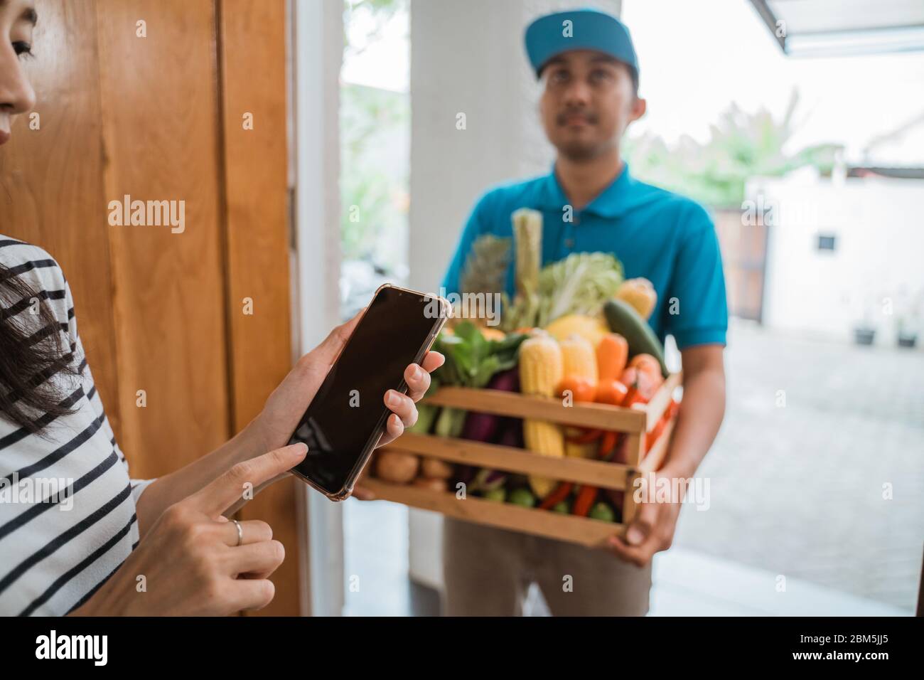 online grocery shopping. delivery man delivering food to a person at
