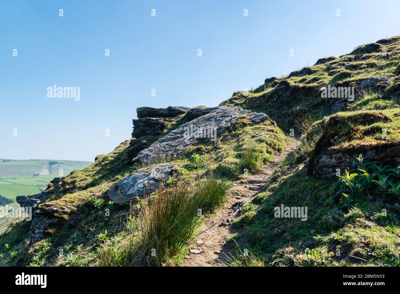 Steep path climbing between boulders on a hill Stock Photo