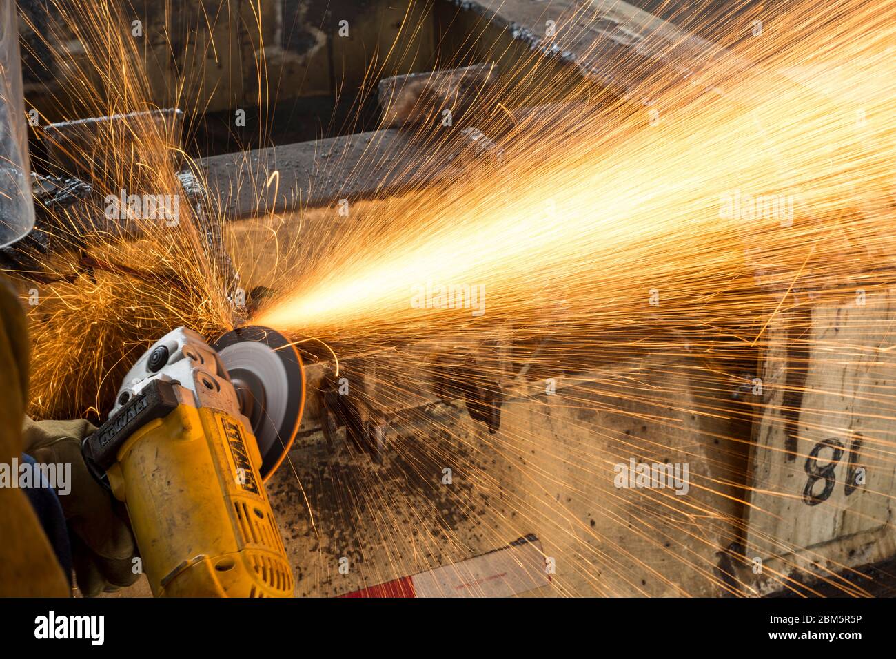 Working with grinding machine in a truck, Industrial worker Stock Photo