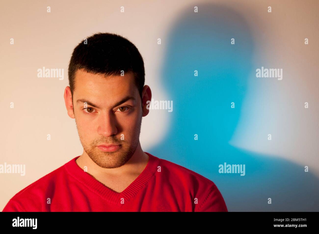Young man, wearing red sweater, looking at the camera. Stock Photo