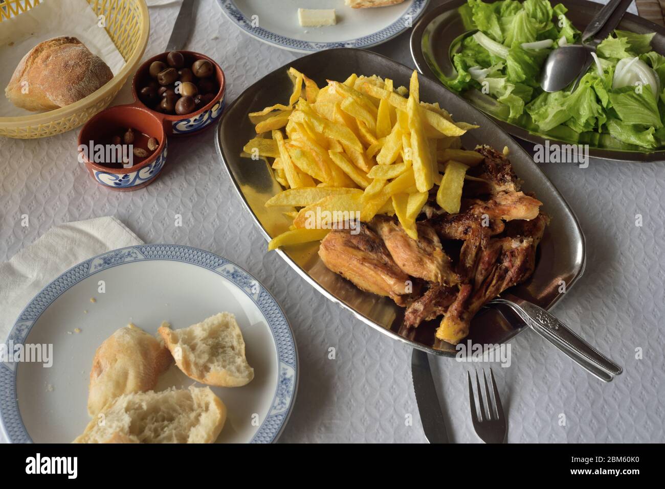 A simple meal at a roadside cafe in Portugal - grilled chicken,chips,bread,olives,salad Stock Photo