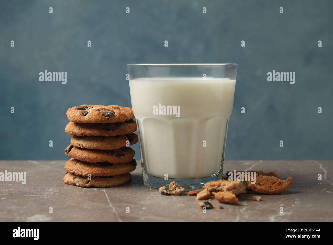 Chocolate chip cookies and glass of milk on brown table Stock Photo
