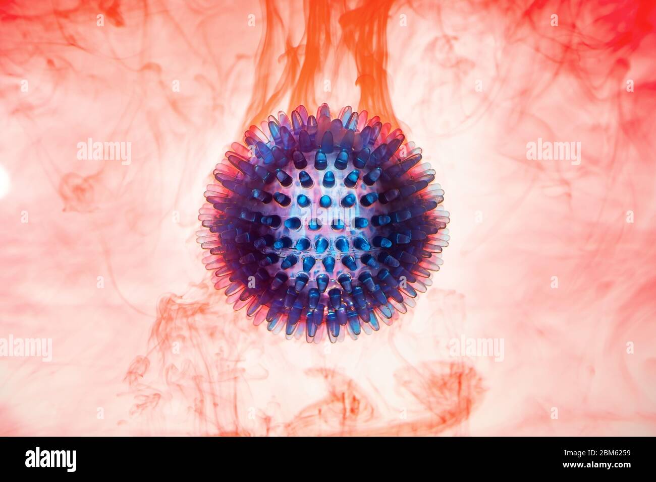 Rubber ball, simulation, coronavirus, pandemic bacteria model on red-white background in blood. Copy space. Stock Photo