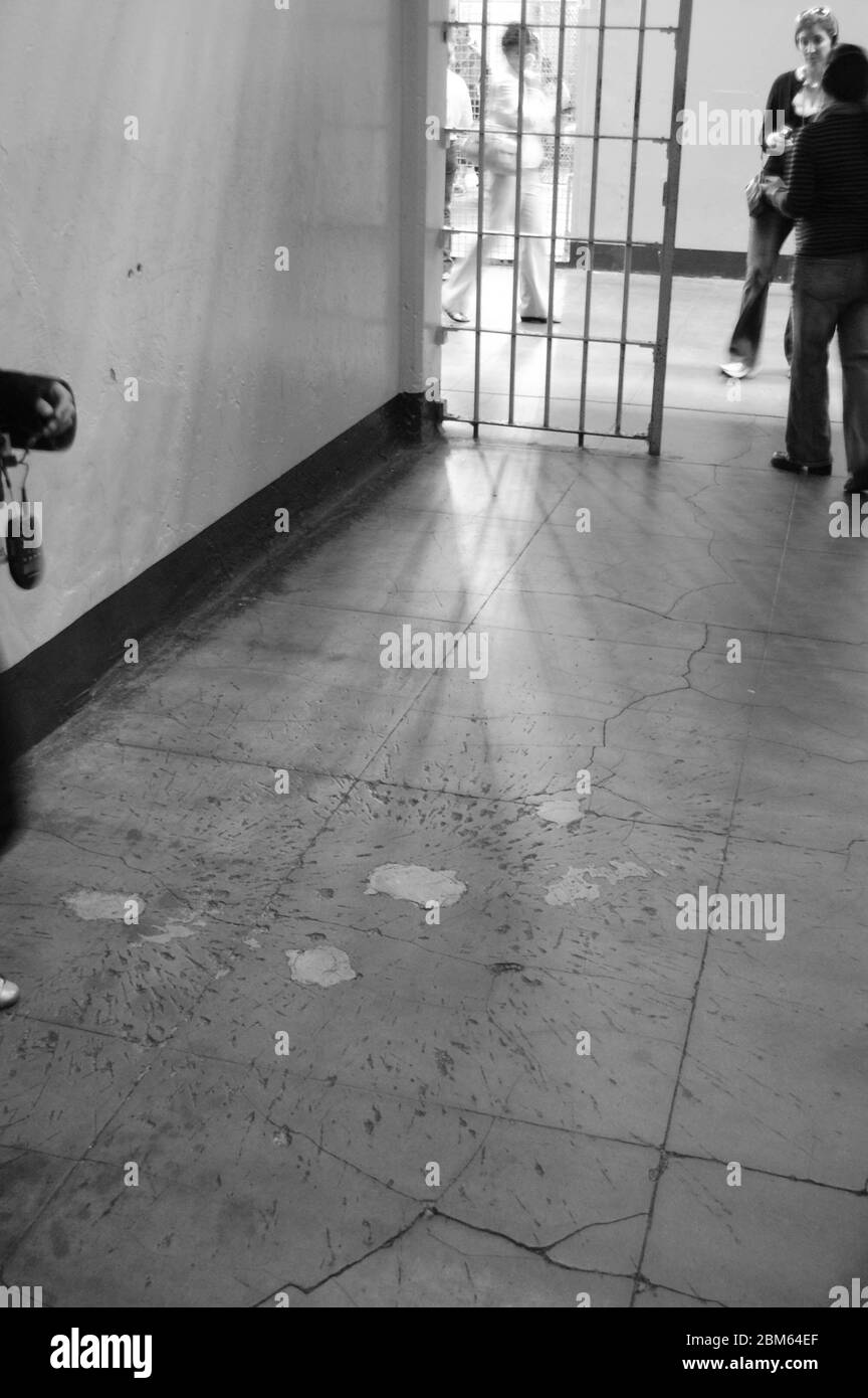 Inside a prison cell Alcatraz California USA with gates in black and white damaged floor explosion hand grenade broken floor blood death killed fight Stock Photo