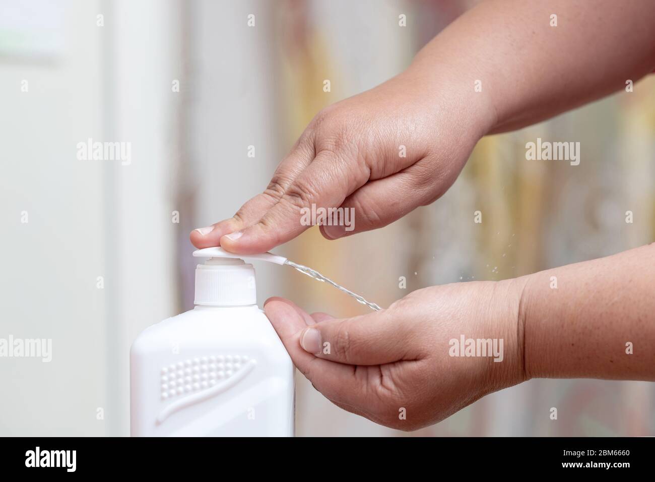 Disinfecting your hands with sanitizer for disinfection and killing the viruses on your hands. Stock Photo