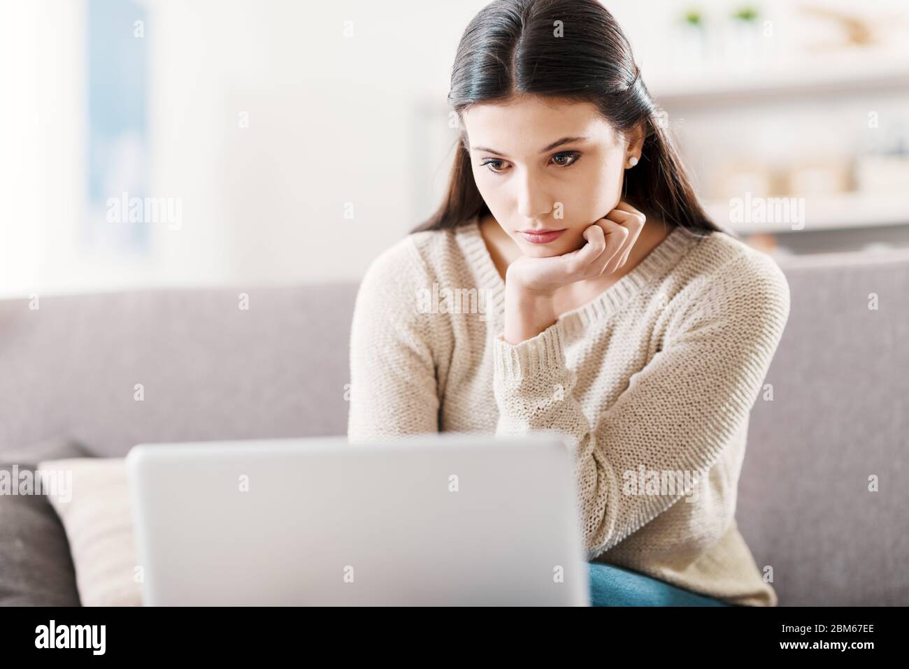 Girl relaxing on the couch at home and using a laptop, technology and communication concept Stock Photo