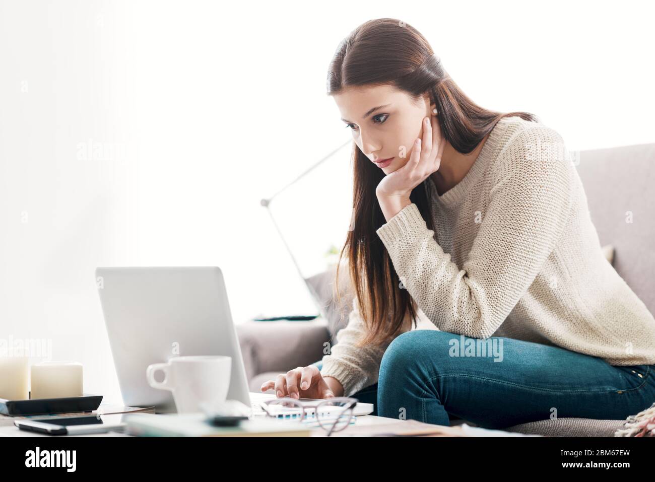 Girl relaxing on the couch at home and using a laptop, technology and communication concept Stock Photo