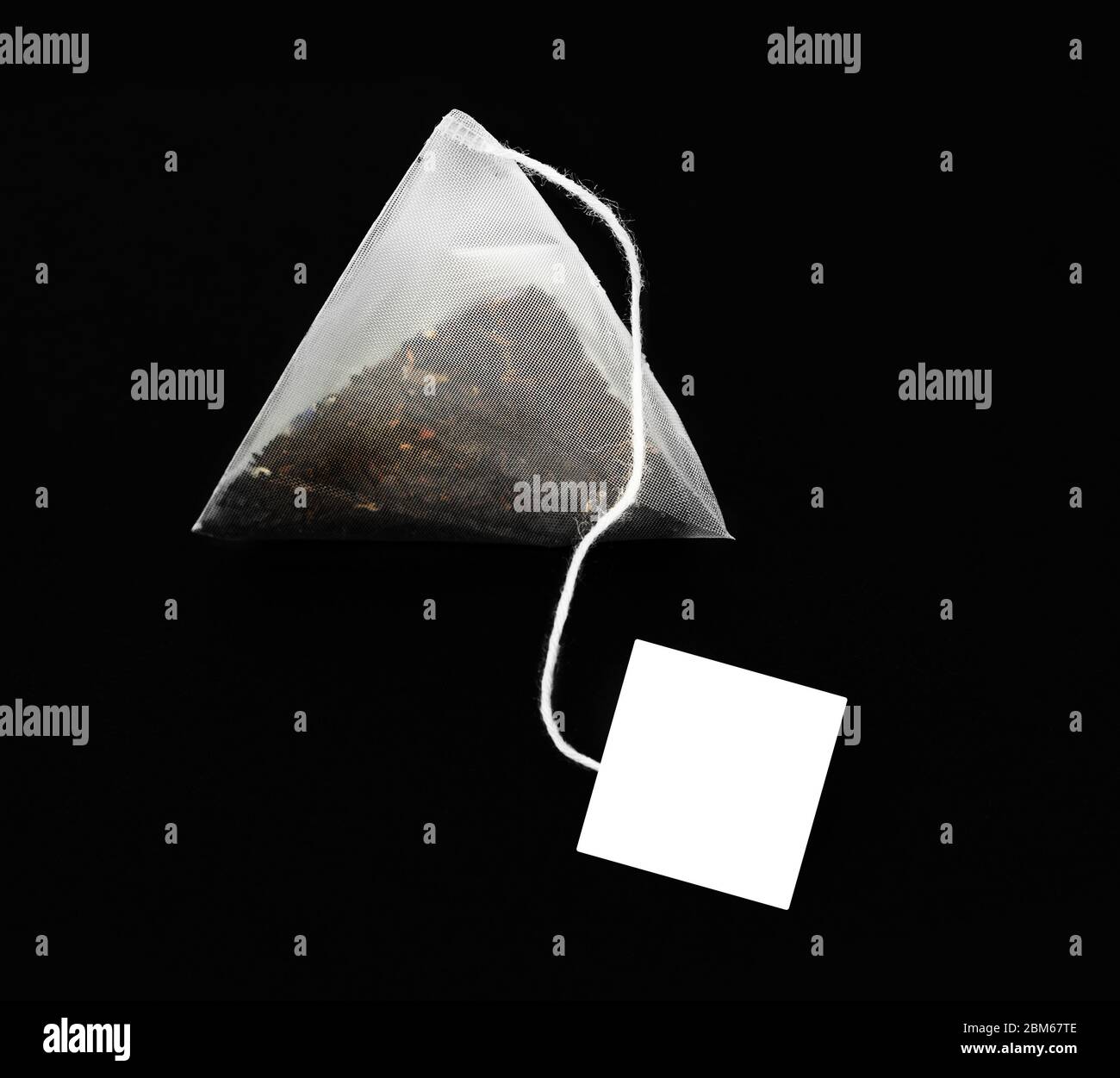 Pyramid shape teabag isolated on the dark background Stock Photo