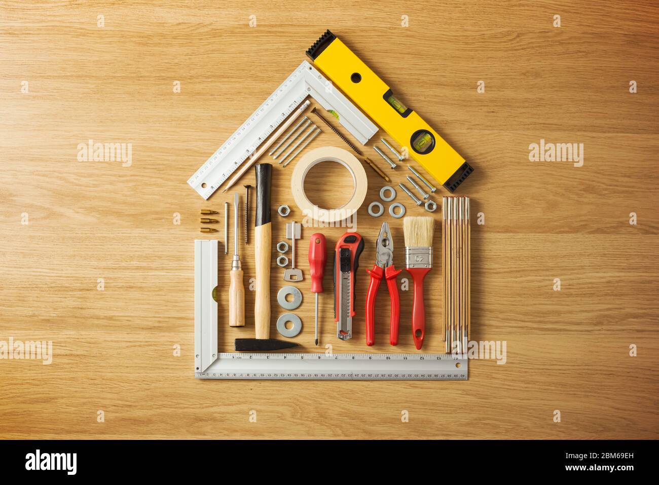 Conceptual house composed of DIY and construction tools on hardwood flooring, top view Stock Photo