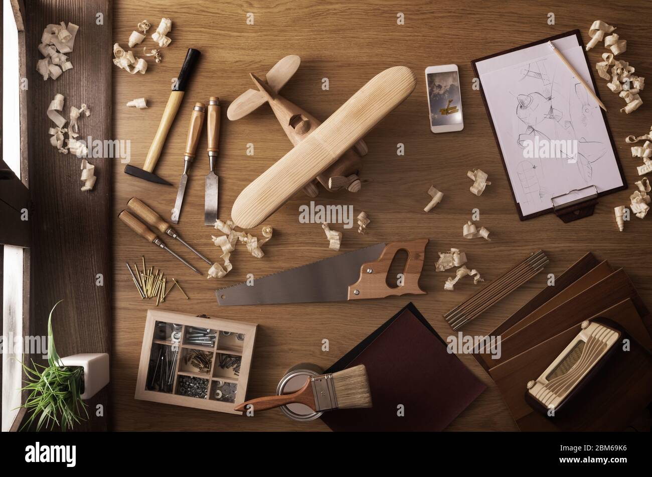 DIY project at home concept, work table with handmade wooden toy airplane and carpentry work tools, top view Stock Photo