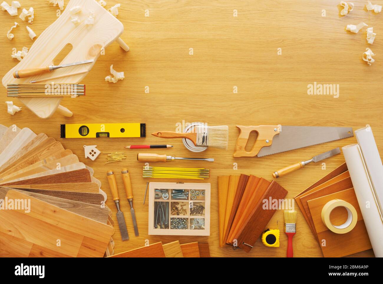 DIY workbench top view with carpentry and construction tools, wooden footstool with shavings and copy space on top Stock Photo