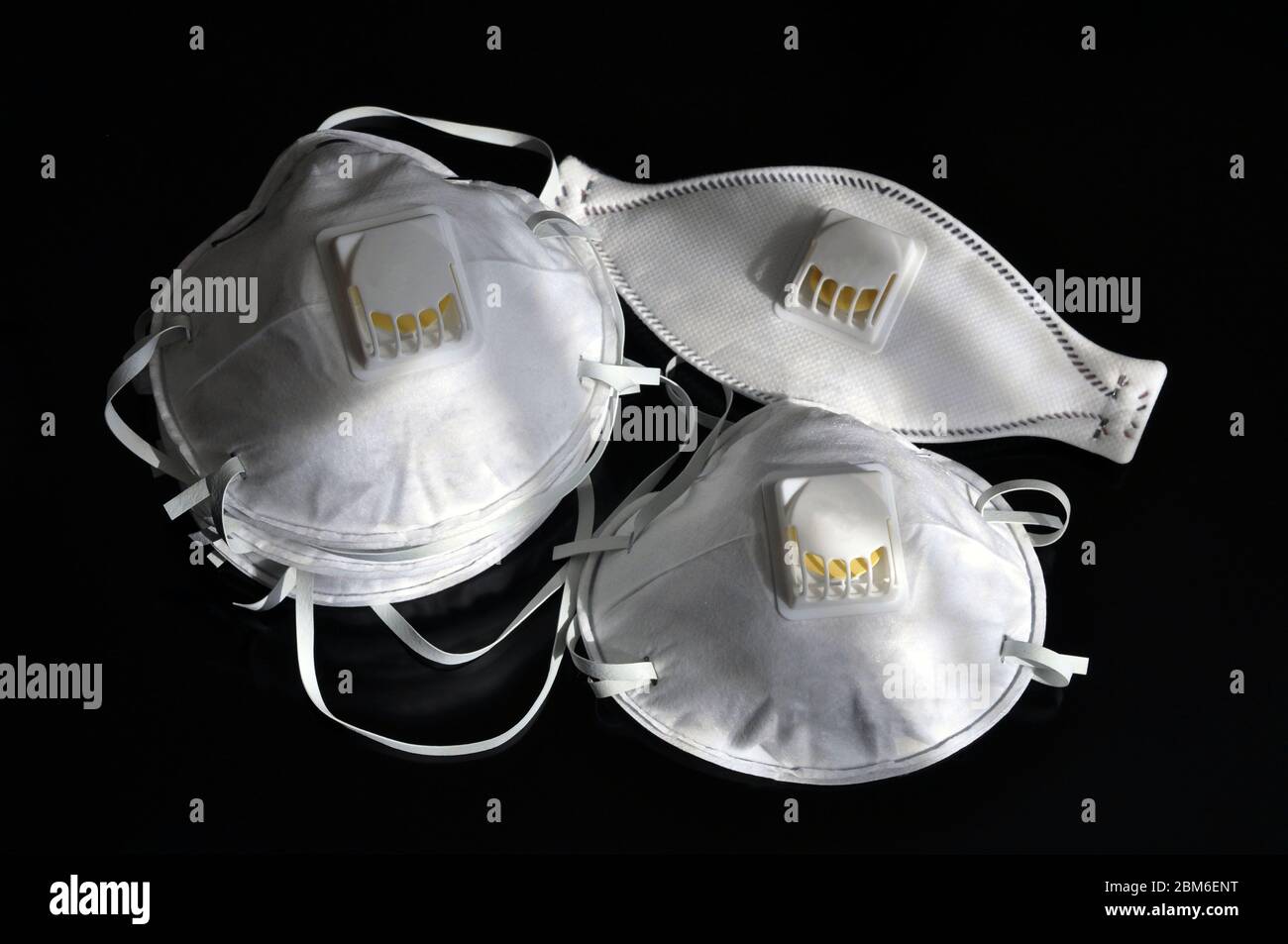 Set of white masks on a black background. Respirator with ventilation ...