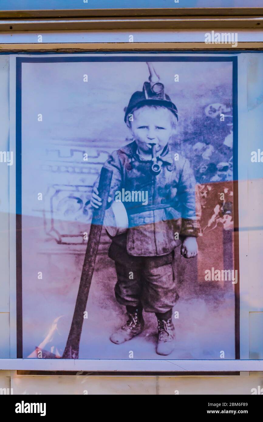 Humorous historic photo of a young child wearing coal mining gear and smoking a pipe on Main Street in Helper, Utah, USA [Note: No property release; p Stock Photo