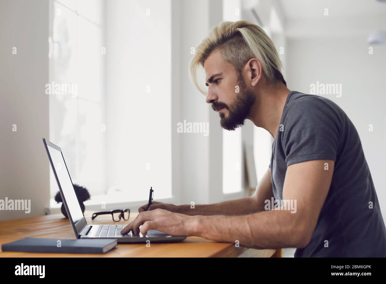 Education learning study online video call chat. Male student smiling is studying an online lesson with a teacher using a laptop webcam at home. Stock Photo