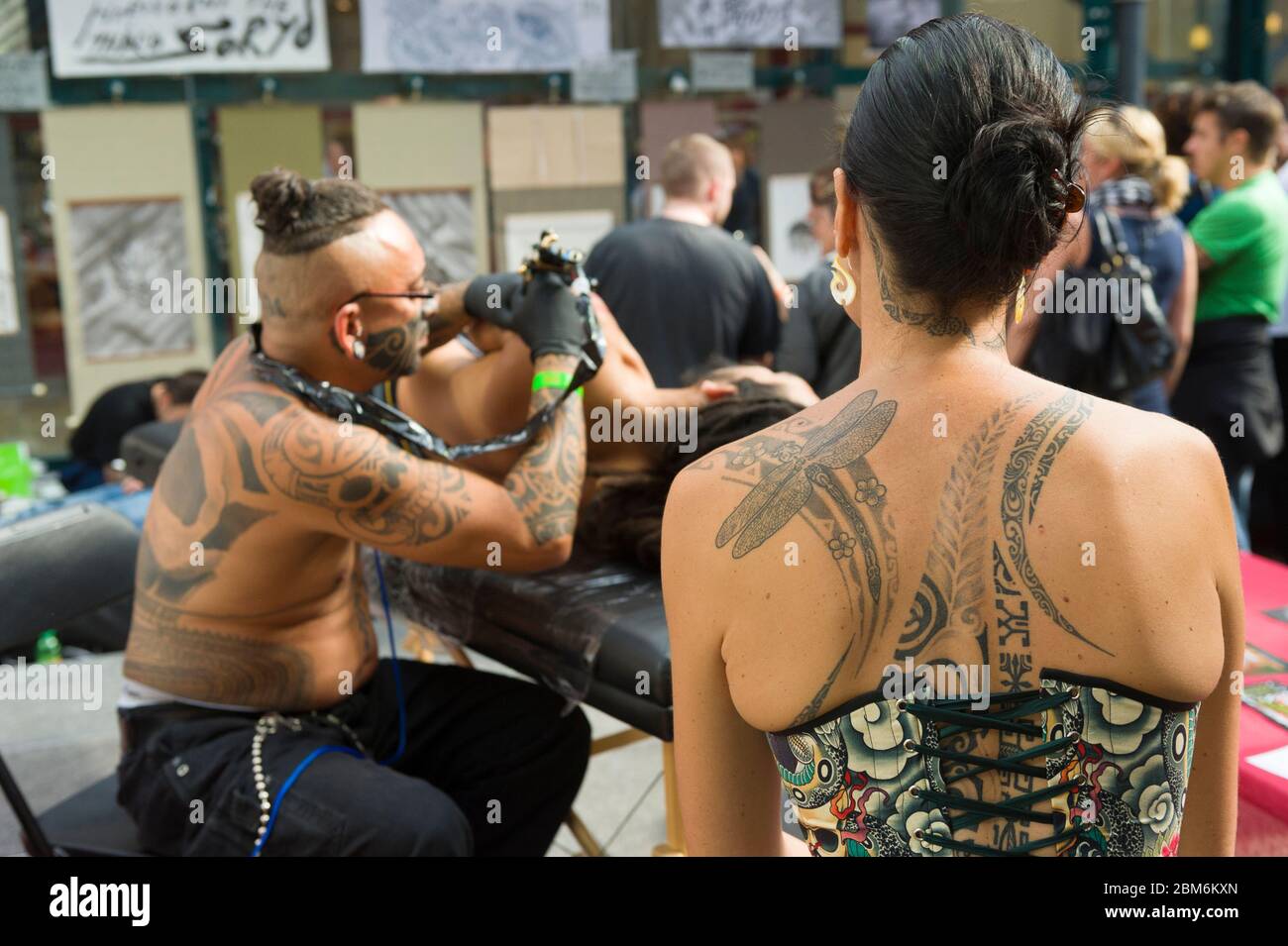 tobacco dock 50 porters walk Woman watching a man being tattooed at The London Tattoo Convention, Tobacco  Dock, 50 Porters Walk, London, UK. 26 Sep Stock Photo