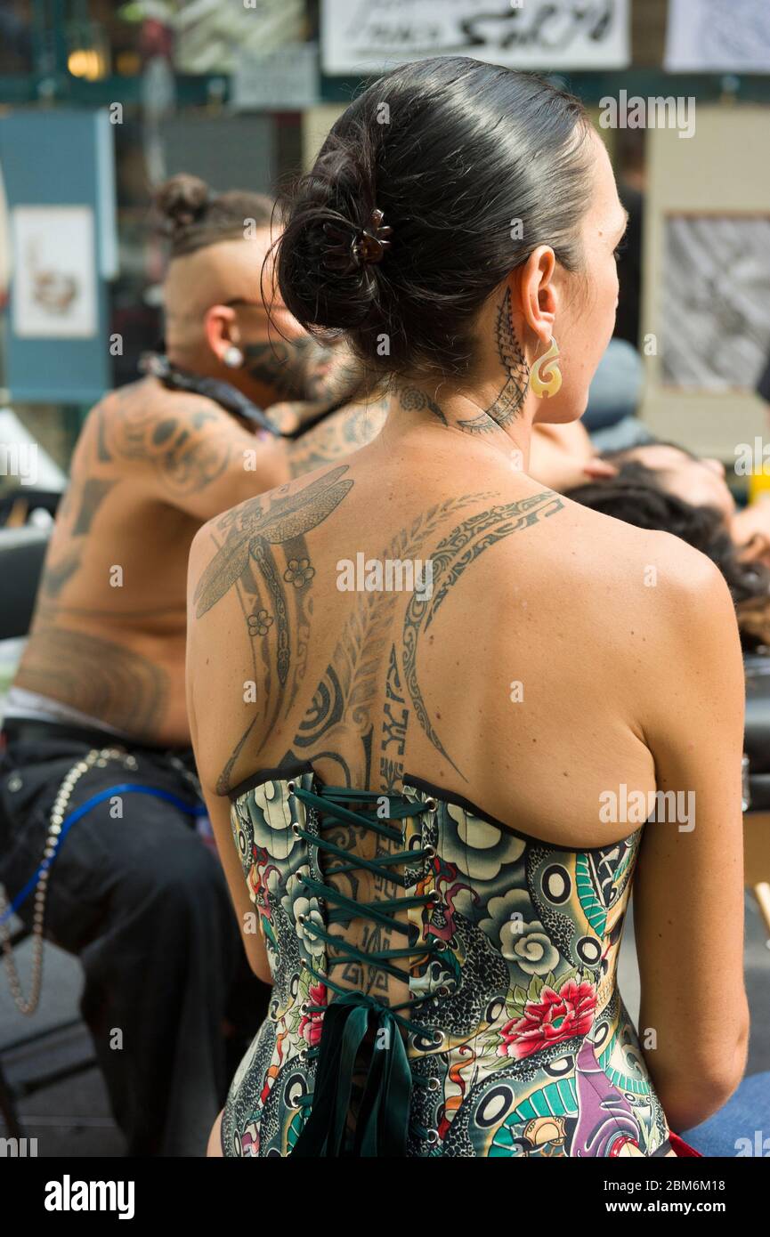 Woman watching a man being tattooed at The London Tattoo Convention, Tobacco  Dock, 50 Porters Walk, London, UK. 26 Sep Stock Photo