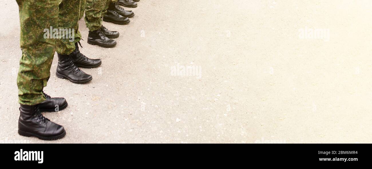 Army soldiers in camouflage uniforms and footwear boots in a resting