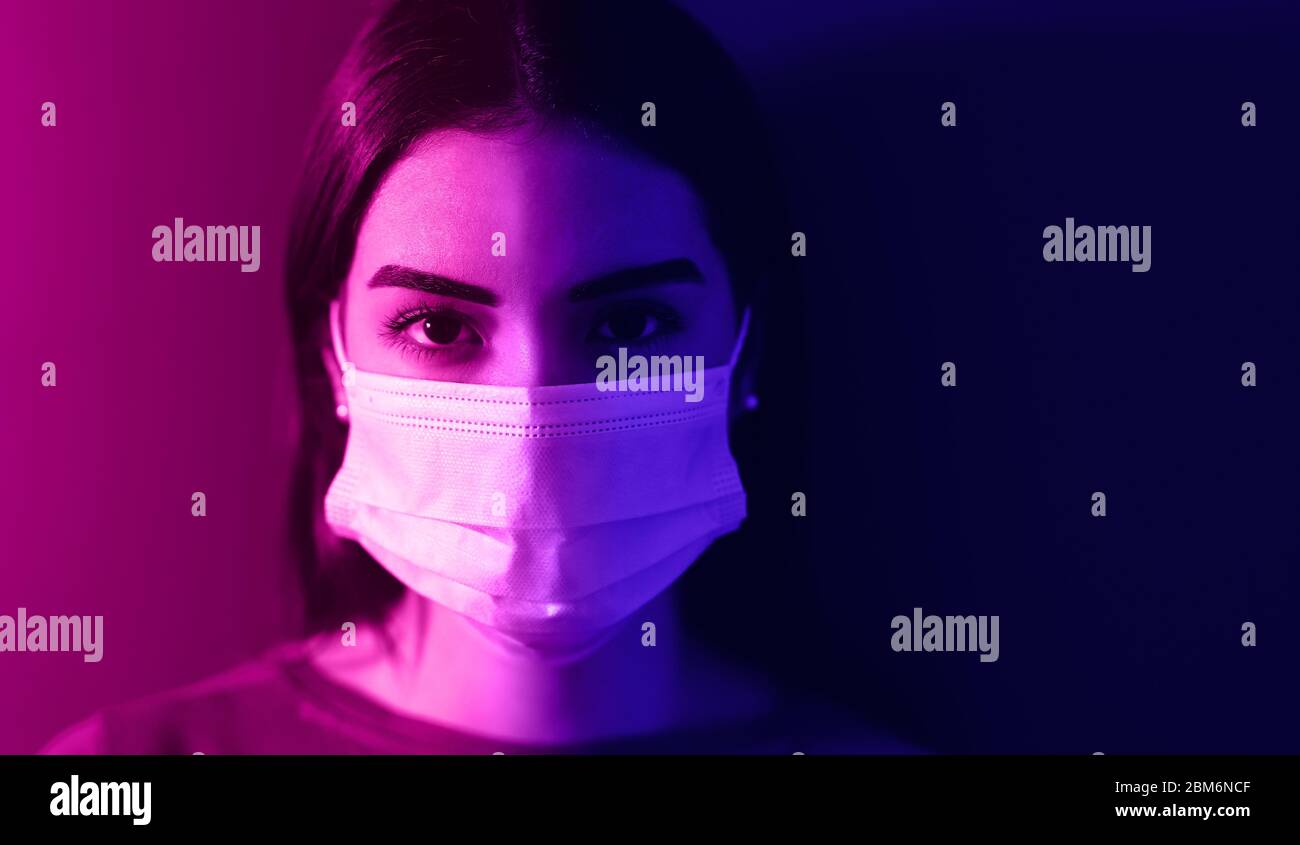 Young woman wearing medical mask against corona virus - Fear girl quarantine for preventing pandemic spread of coronavirus Stock Photo