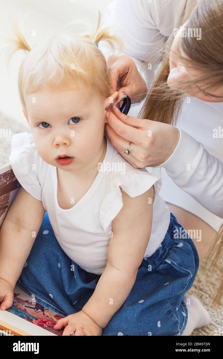 Baby girl wearing a hearing aid. Disabled child, disability and