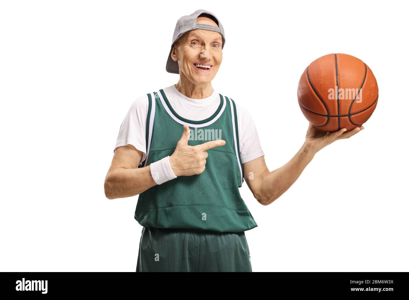 Cheerful elderly man holding a basketball and pointing isolated on white  background Stock Photo - Alamy