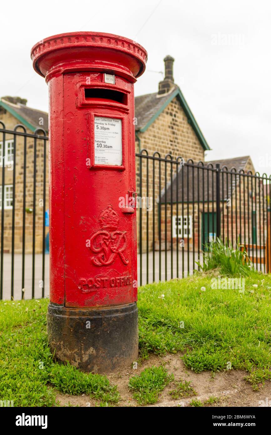 Traditional red post box by Horsley Primary school, Derbyshire, England Stock Photo