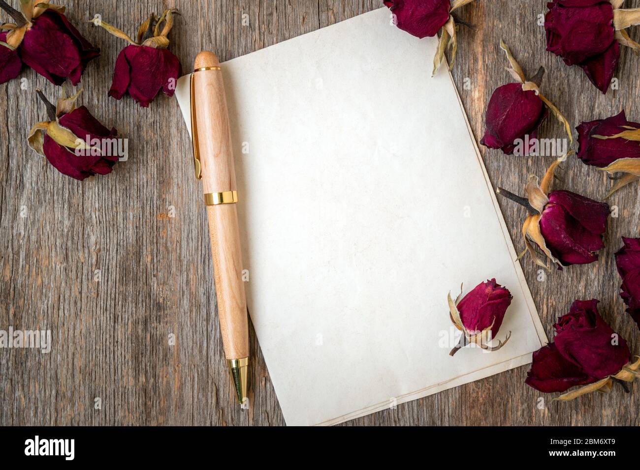 Blank paper with dry roses on wooden background. Love letter. Copy space  Stock Photo - Alamy