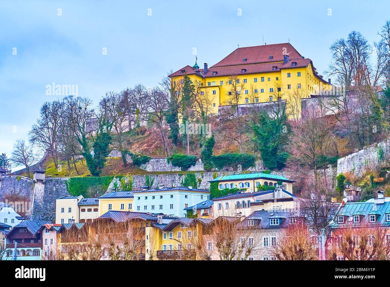 The monumental Kapuzinerkloster (Capuchin monastery) with medieval walls on the peak of Kapuzinerberg hill dominating over surrounding houses, Salzbur Stock Photo