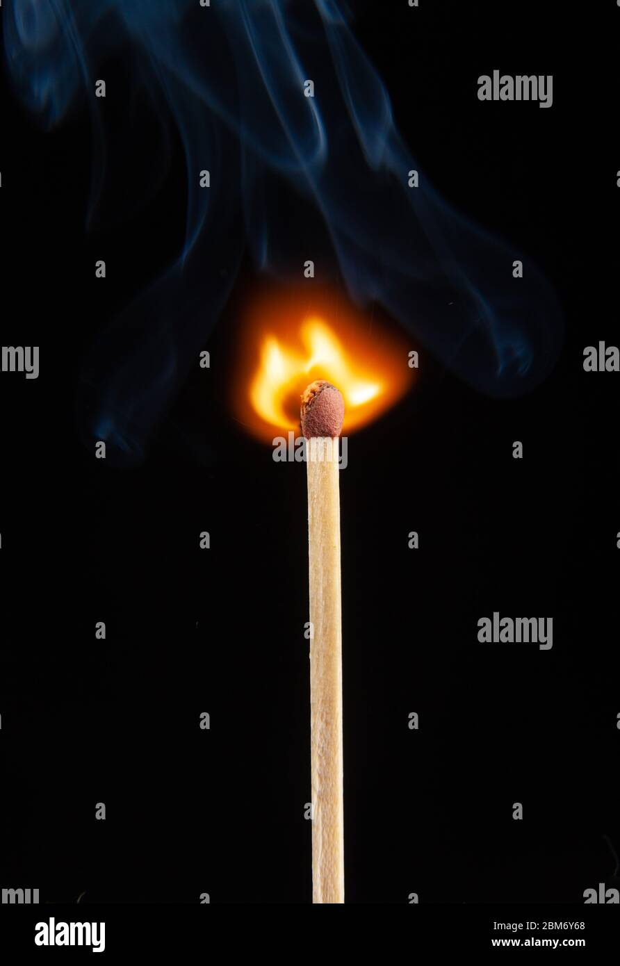 A burning matchstick on black background Stock Photo