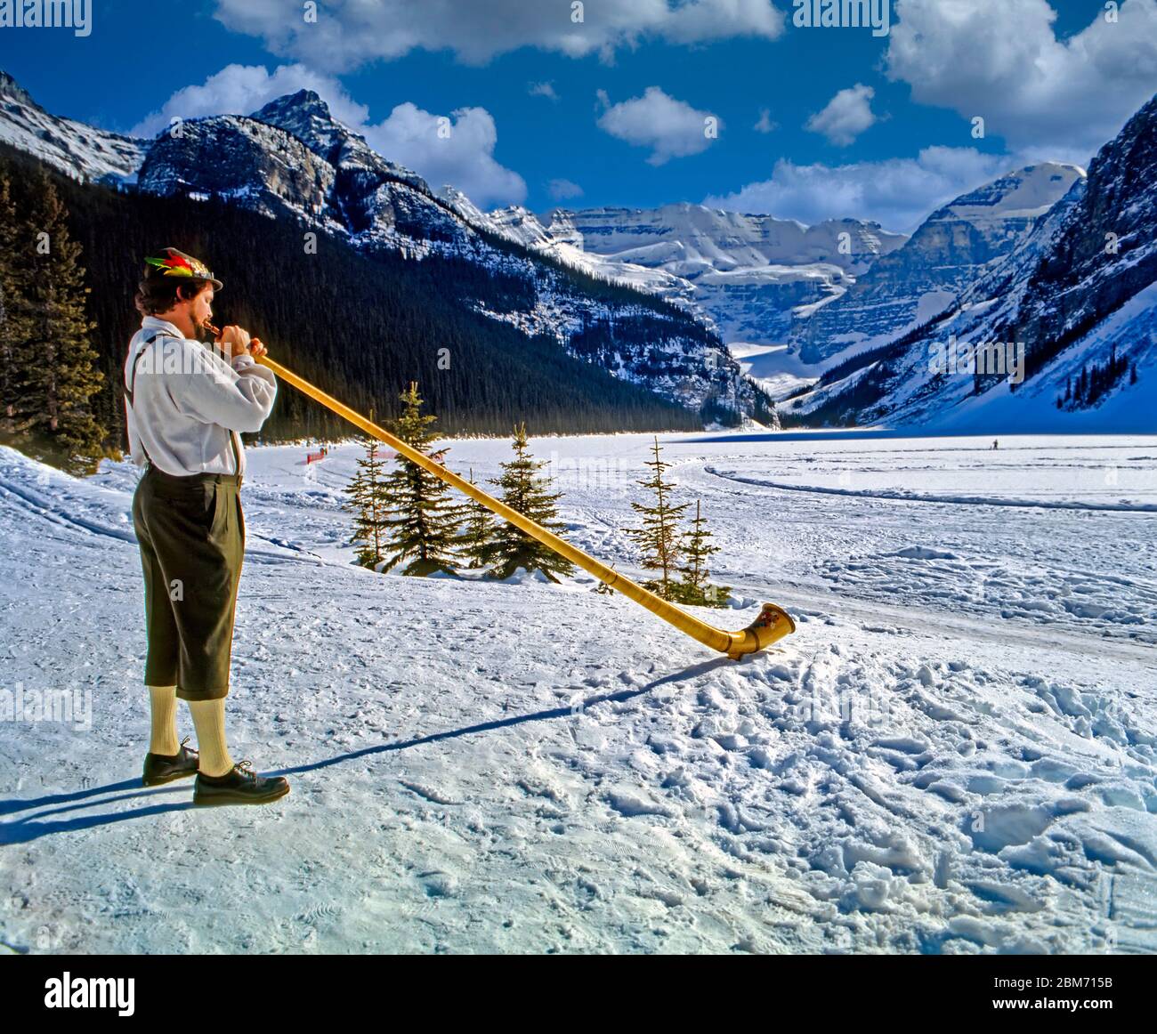 Man Playing Alpen Horn in Canada, Alberta, Banff National Park, in the winter, with snow and people enjoying the outdoors Stock Photo